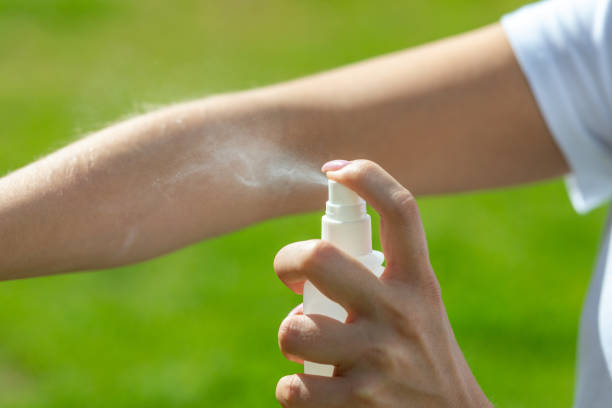 Woman spraying mosquito insect repellen