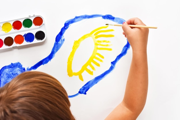 mano-ninos-pincel-pinta-nube-azul-sobre-sabana-blanca-sol-amarillo-pinturas-acuarela-pinceles-pintar-creatividad-ninos-pintando-desarrollo-temprano_323960-1544