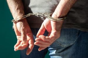 vista-recortada-hombre-esposado-jeans-pie-aislado-verde_137728-294